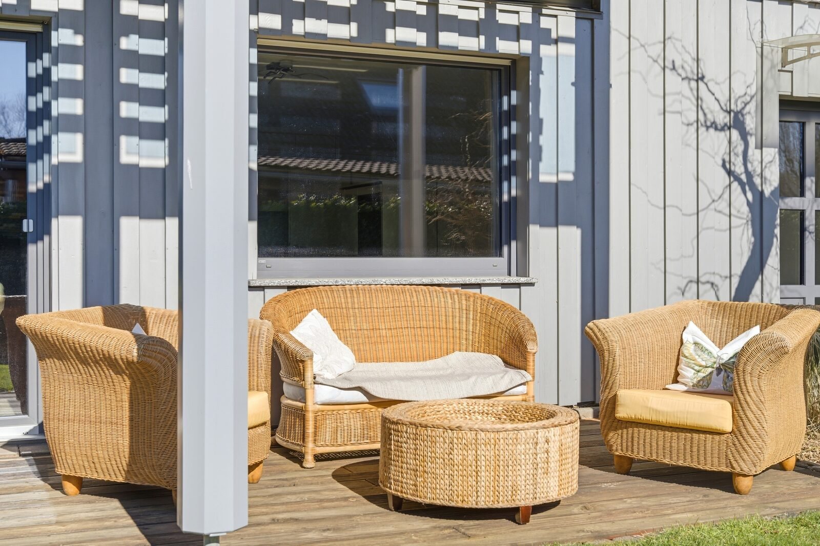 Terrasse mit Korbmöbeln im Sonnenlicht